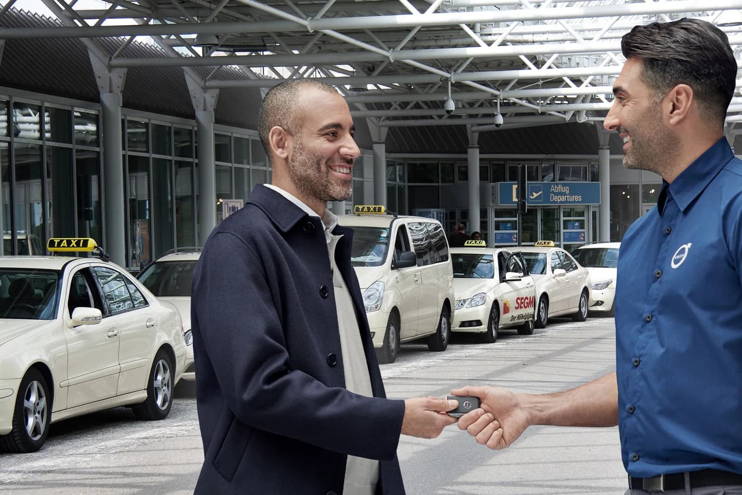 Kunde übergibt Autoschlüssel an Valet-Mitarbeiter am Flughafenterminal